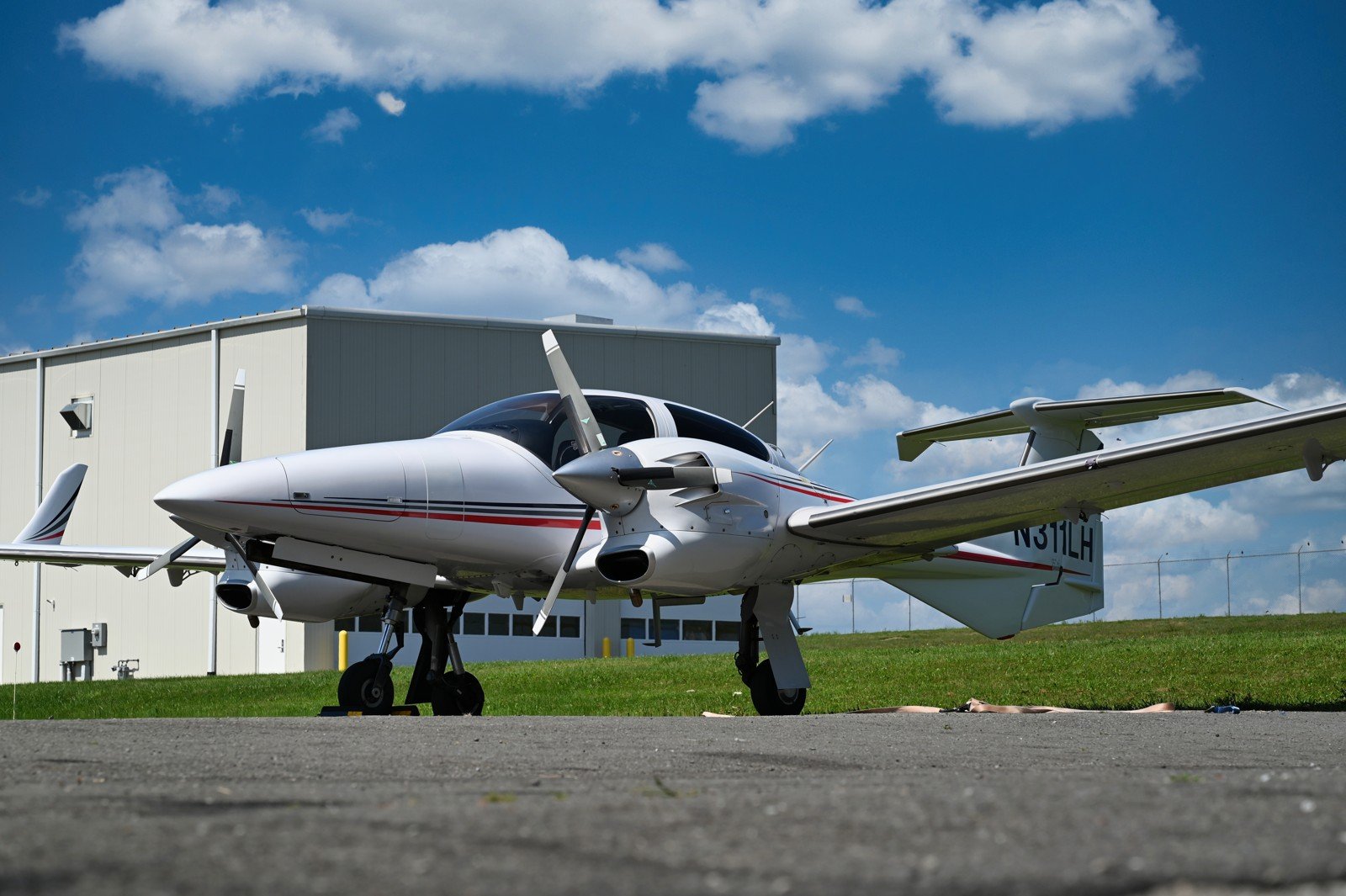 White Diamond twin parked in front of a hangar under a blue sky