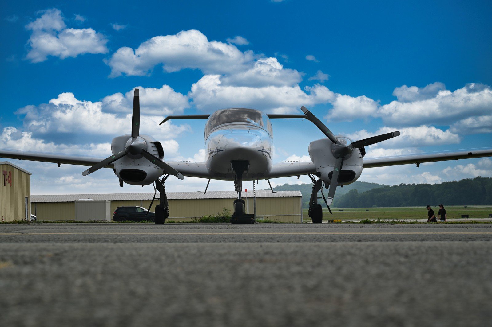 Head-on view of a Diamond twin on the ramp under puffy clouds